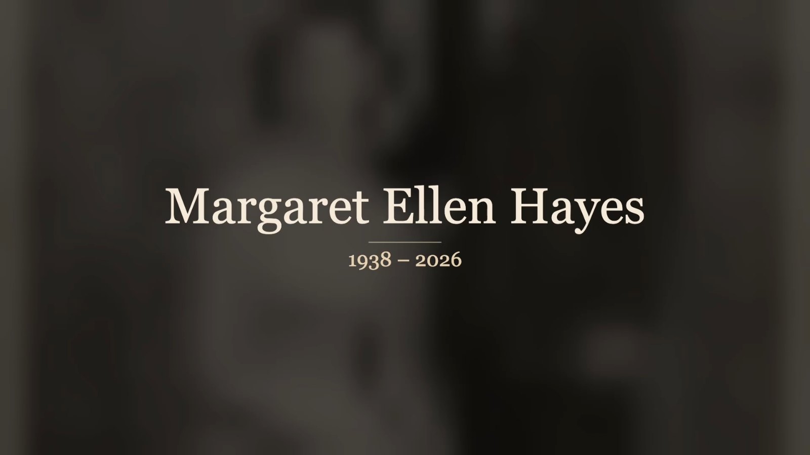 A memorial video title card with a name and dates over a softly blurred photo