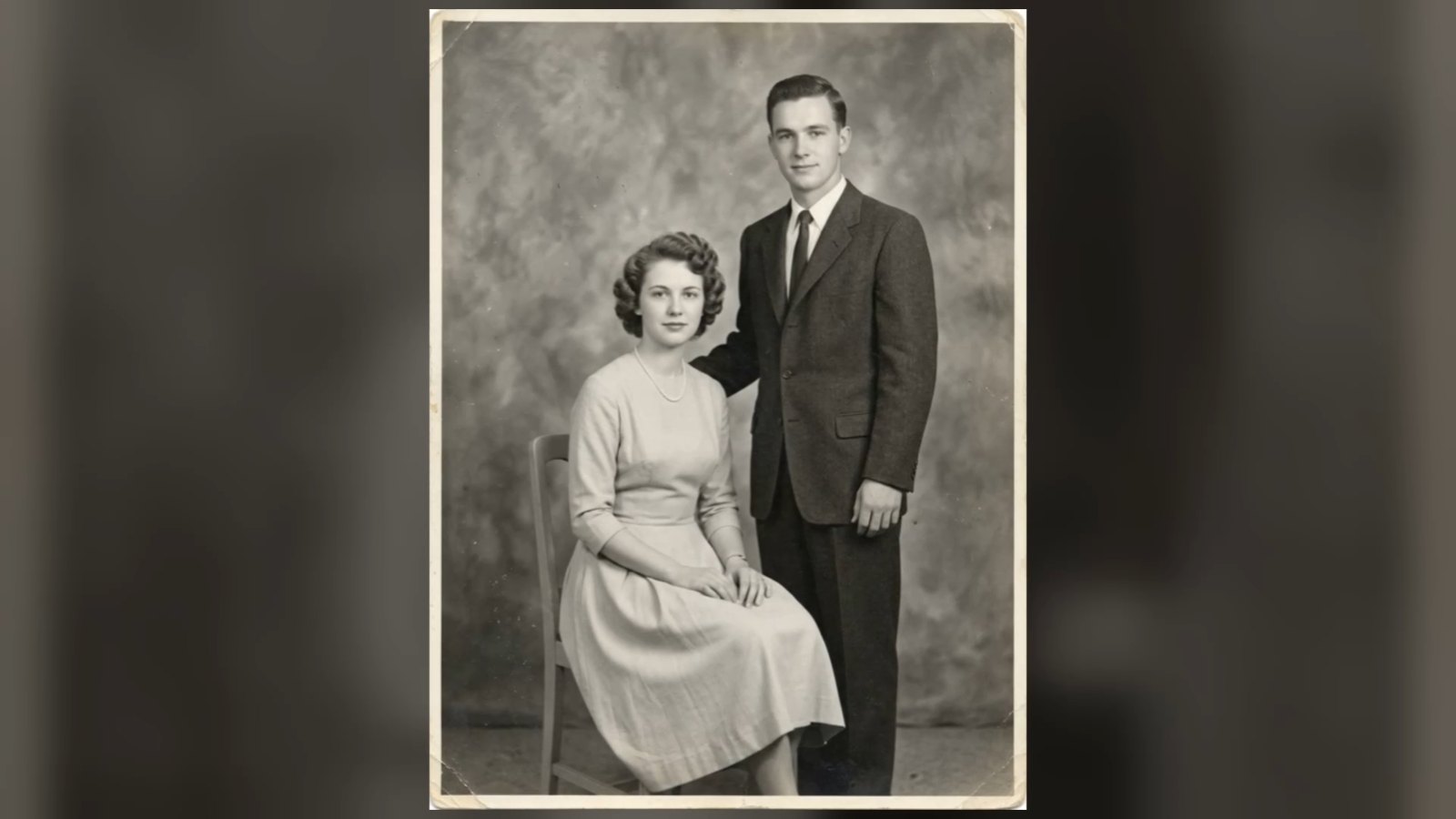A still from a tribute video: an old black-and-white couple portrait on a softly blurred background